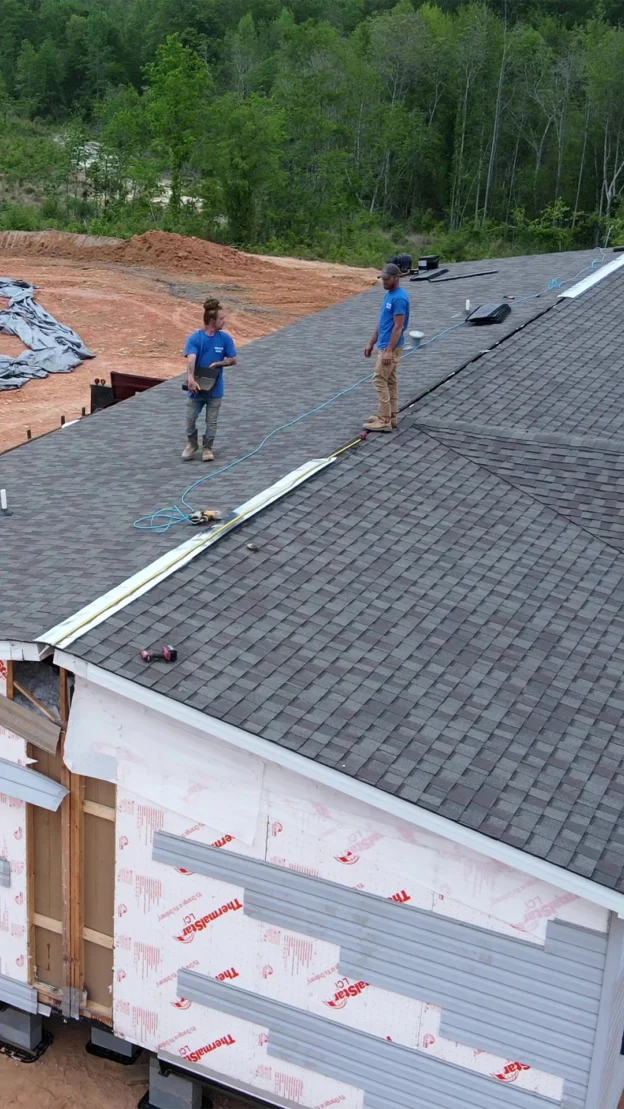 two roofers on jobsite - drone shot