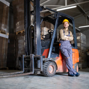 Man smiling and leaning against a forklift.